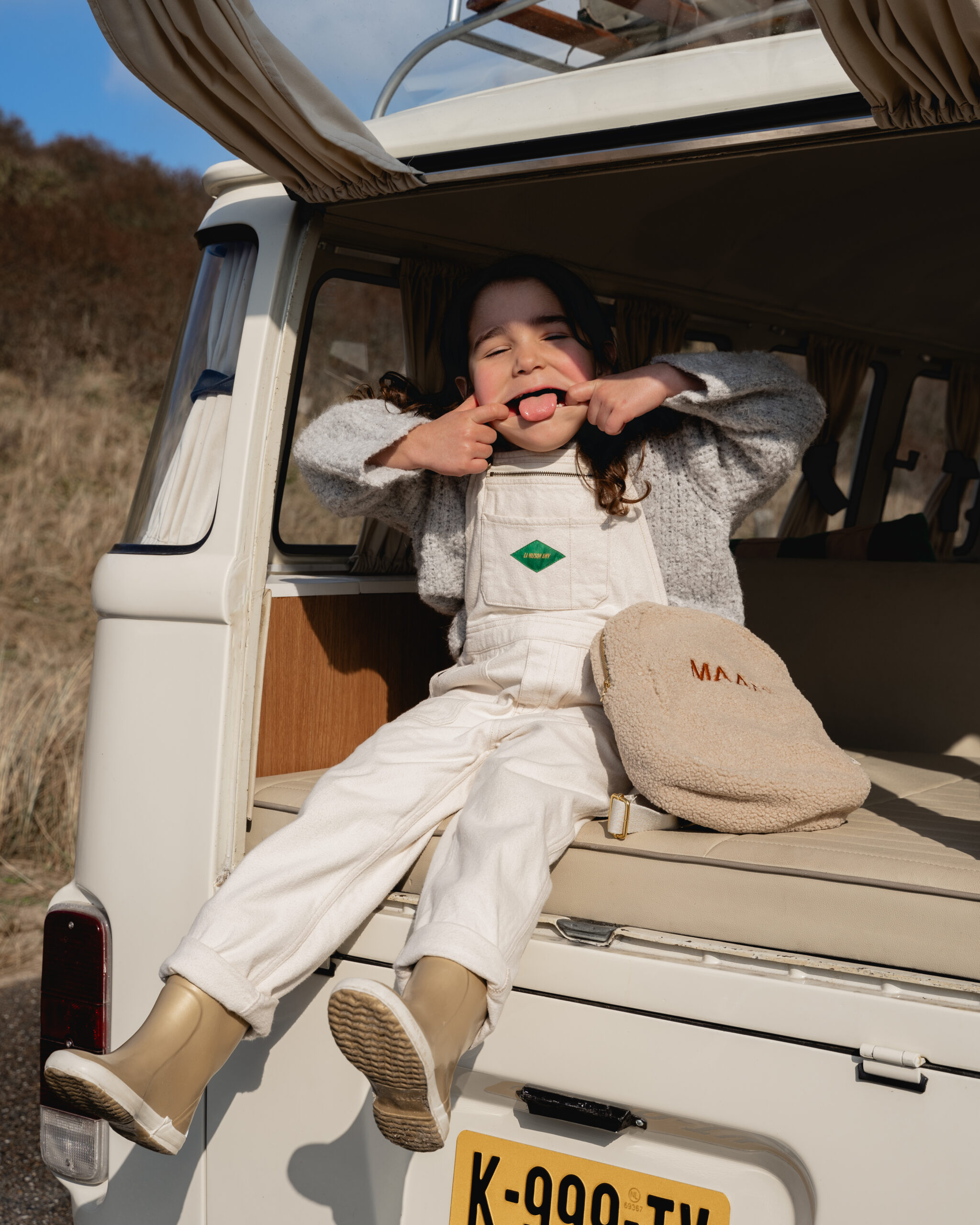 Duinshoot fotoshoot met meisje in een camper voor studio noos